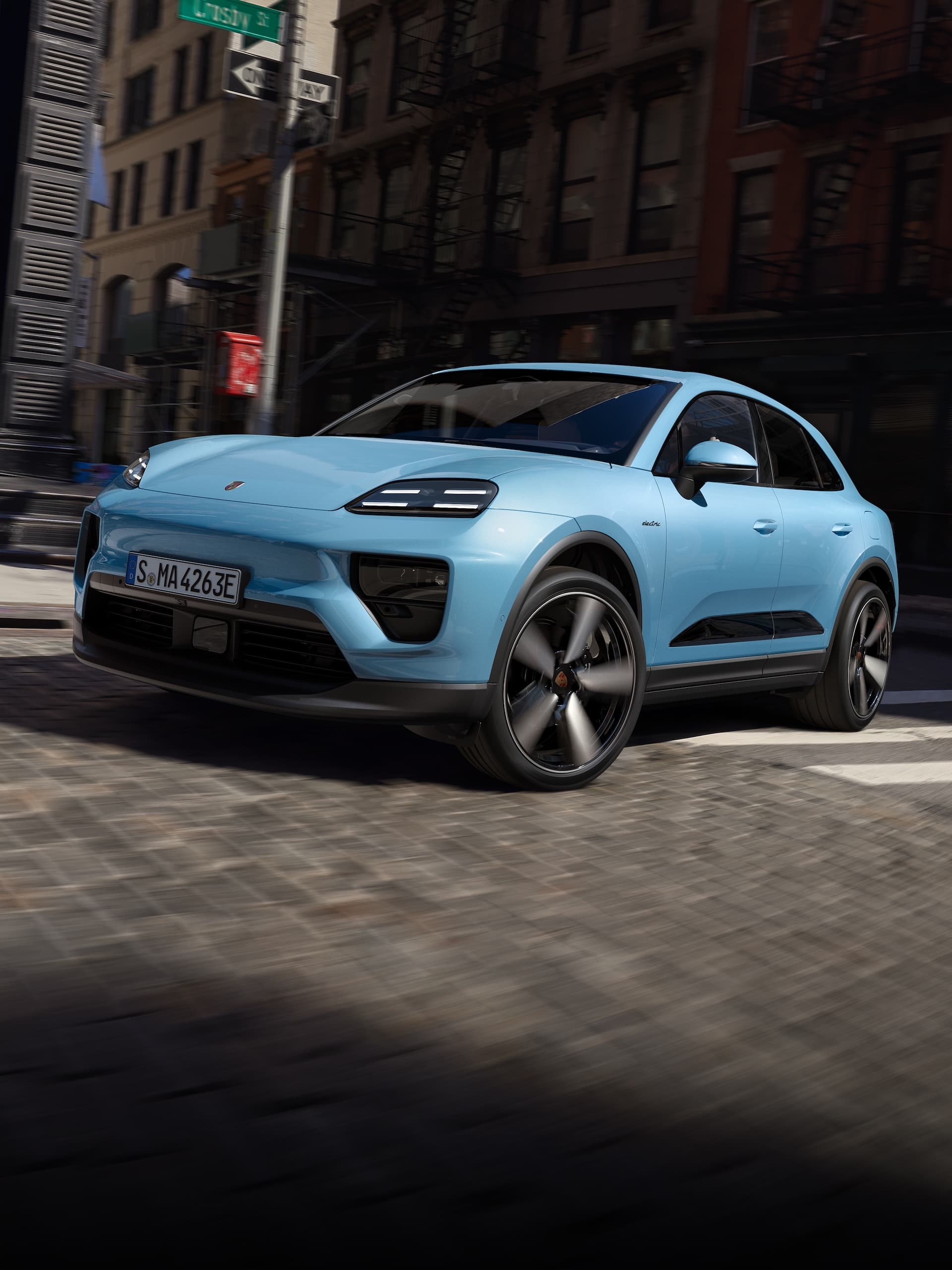 Une Porsche Macan 100% électrique circulant sur une route dans un scénario urbain.